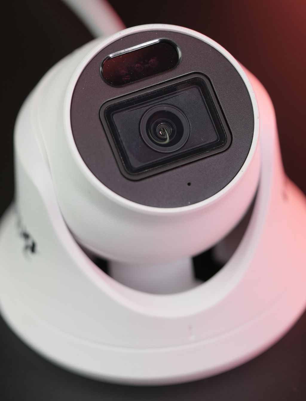 White dome CCTV camera photographed close up with the lens facing the viewer