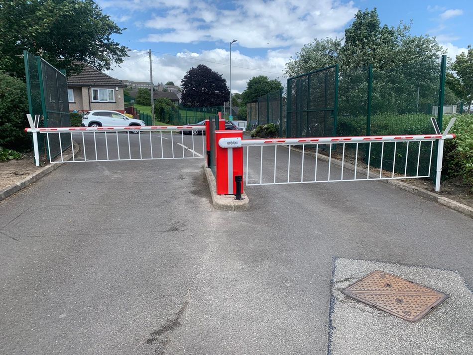 Car park barrier arm in a lowered position, blocking entry to a parking area.